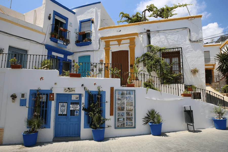 ceci est une image d'un village avec des maisons blanches avec des portes bleues 